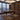 Stanley Furniture Horizon Mid-Century writing desk in a luxury high-rise home office with city skyline view, leather swivel chair, built-in bookcases, and laptop on executive wood desk.